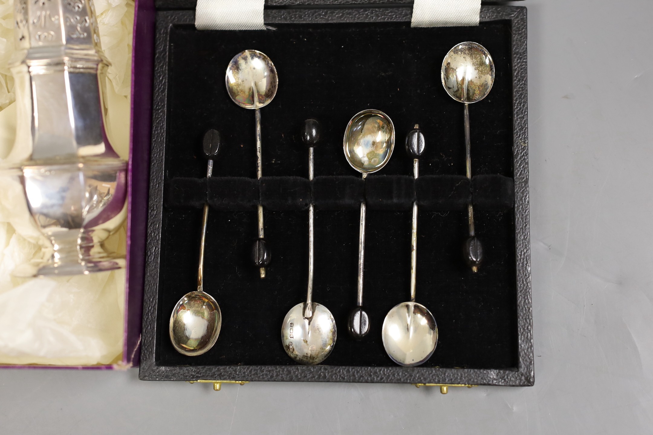 A George I silver octagonal caster, Thomas Bamford, London, 1725, 13.1cm, a cased modern silver commemorative spoon, a cased set of six silver bean end coffee spoons and five plated items.